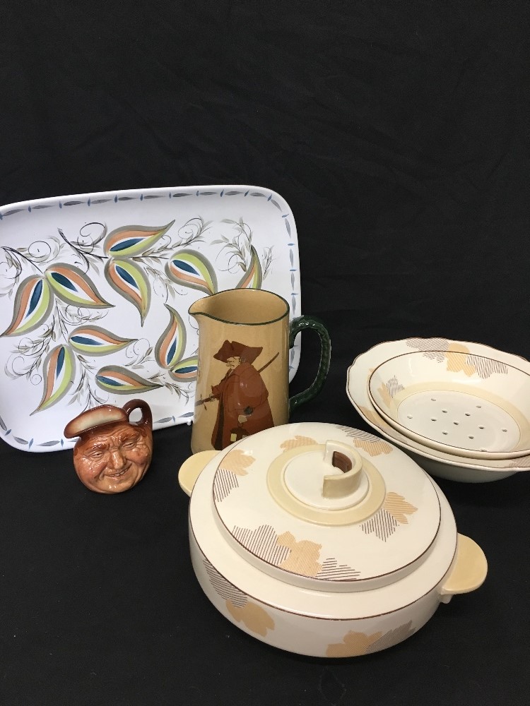 A Royal Doulton strainer and serving bowl, a small toby jug and a large Royal Doulton milk jug.