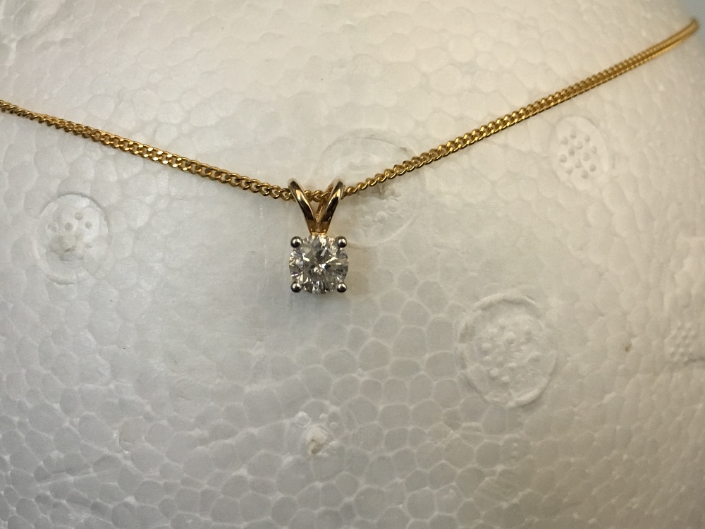 A 9ct yellow gold chain and pendant. The pendant set with a solitaire diamond.
