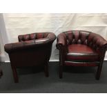 A pair of leather button backed tub chairs in a chesterfield style.