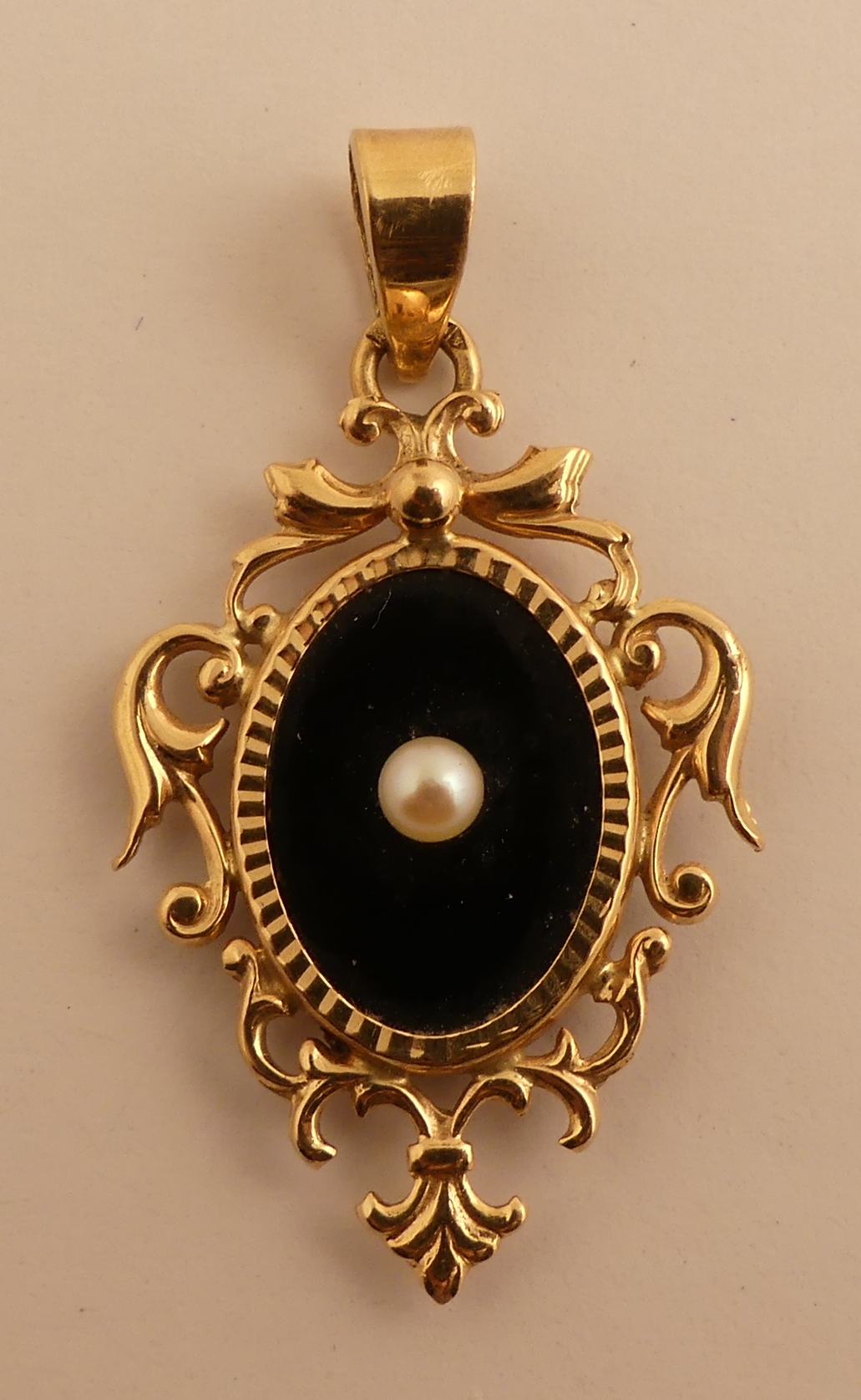 Pendentif en or jaune centré d'onyx et d'une perle. PB. 2.9g. -