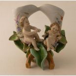 Meissen ? Vase figurant 2 putti en porcelaine. Signé. Fin XIXe.Haut. 19 cm. -