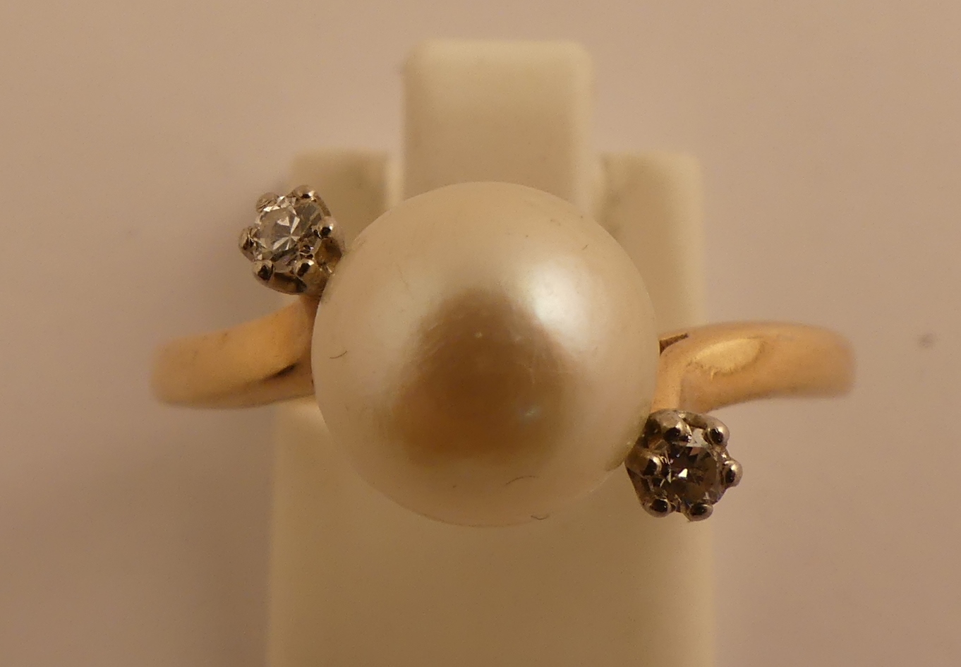 Bague en or jaune centrée d'une perle épaulée de diamants. TDD. 59/60. PB. 3.1g. -