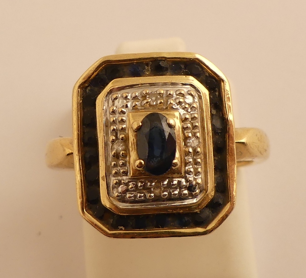 Bague en or jaune centrée d'un saphir de taille ovale entouré de saphir baguettes. [...]