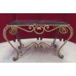 Table basse en fer forgé doré et plateau marbre. Larg. 83 cm. -