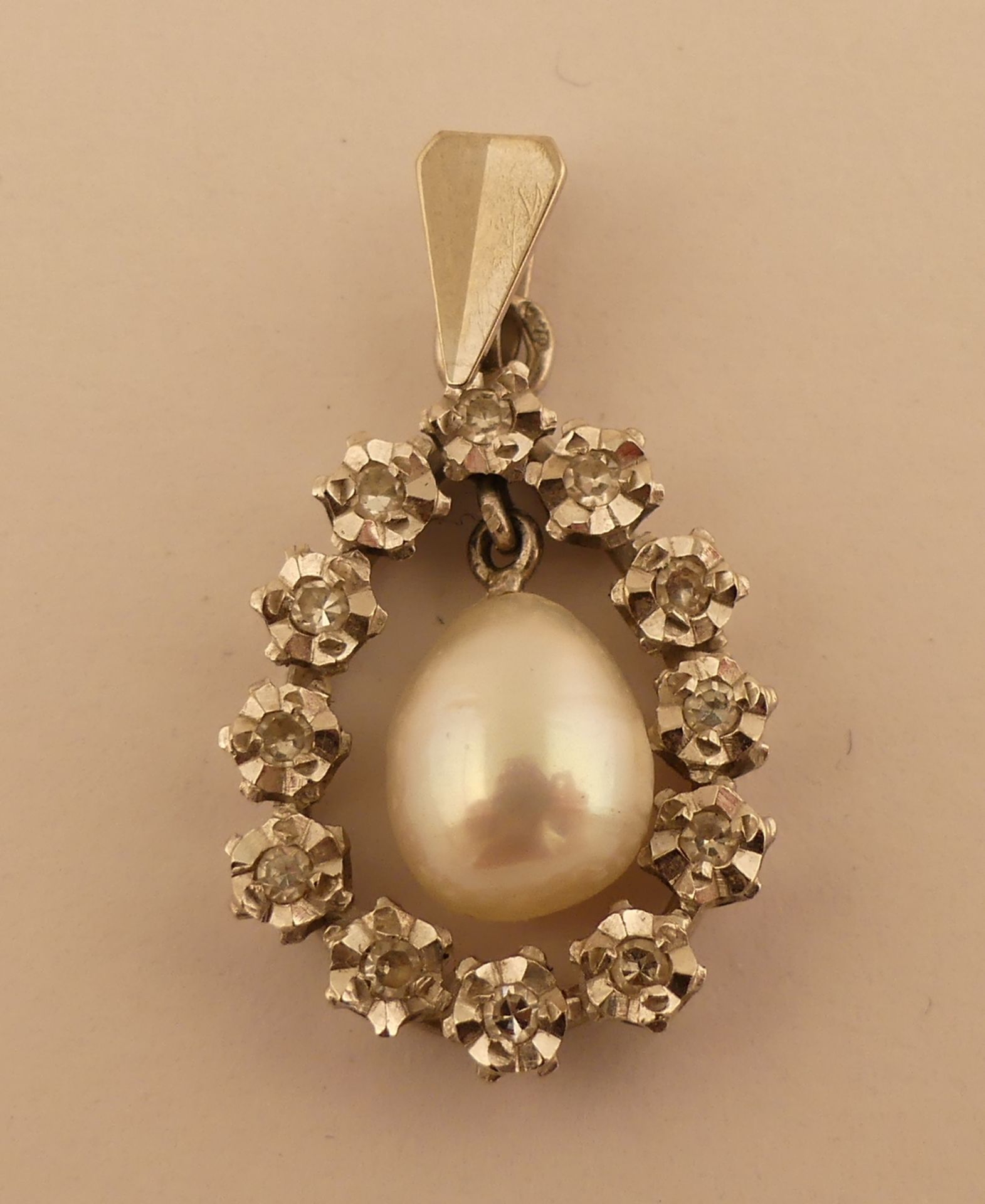 Pendentif en or blanc orné de diamants et centré d'une perle. Haut. 2.6 cm avec [...]