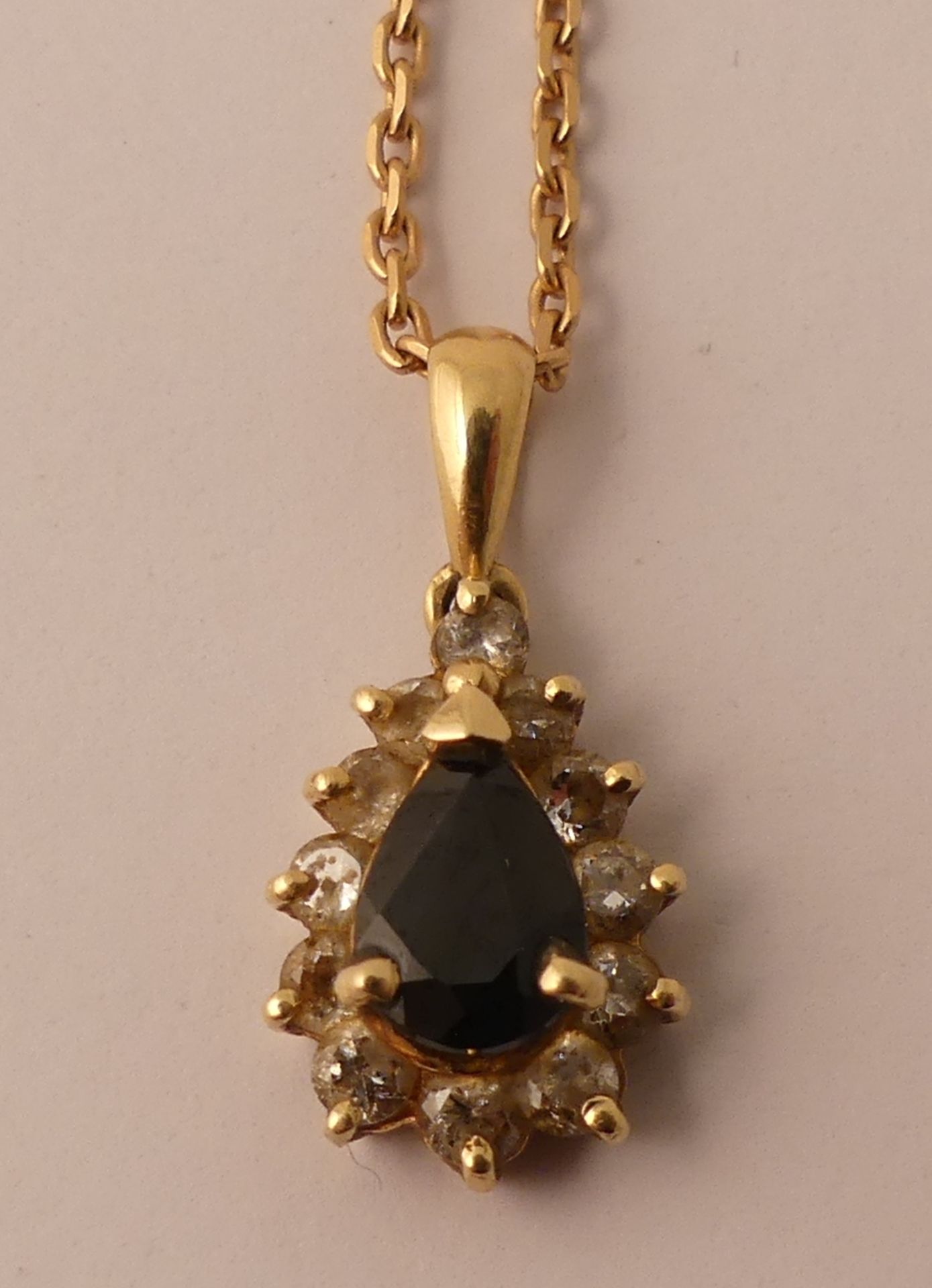 Chaine et pendentif en or jaune centré d'un saphir poire entouré de pierres [...]