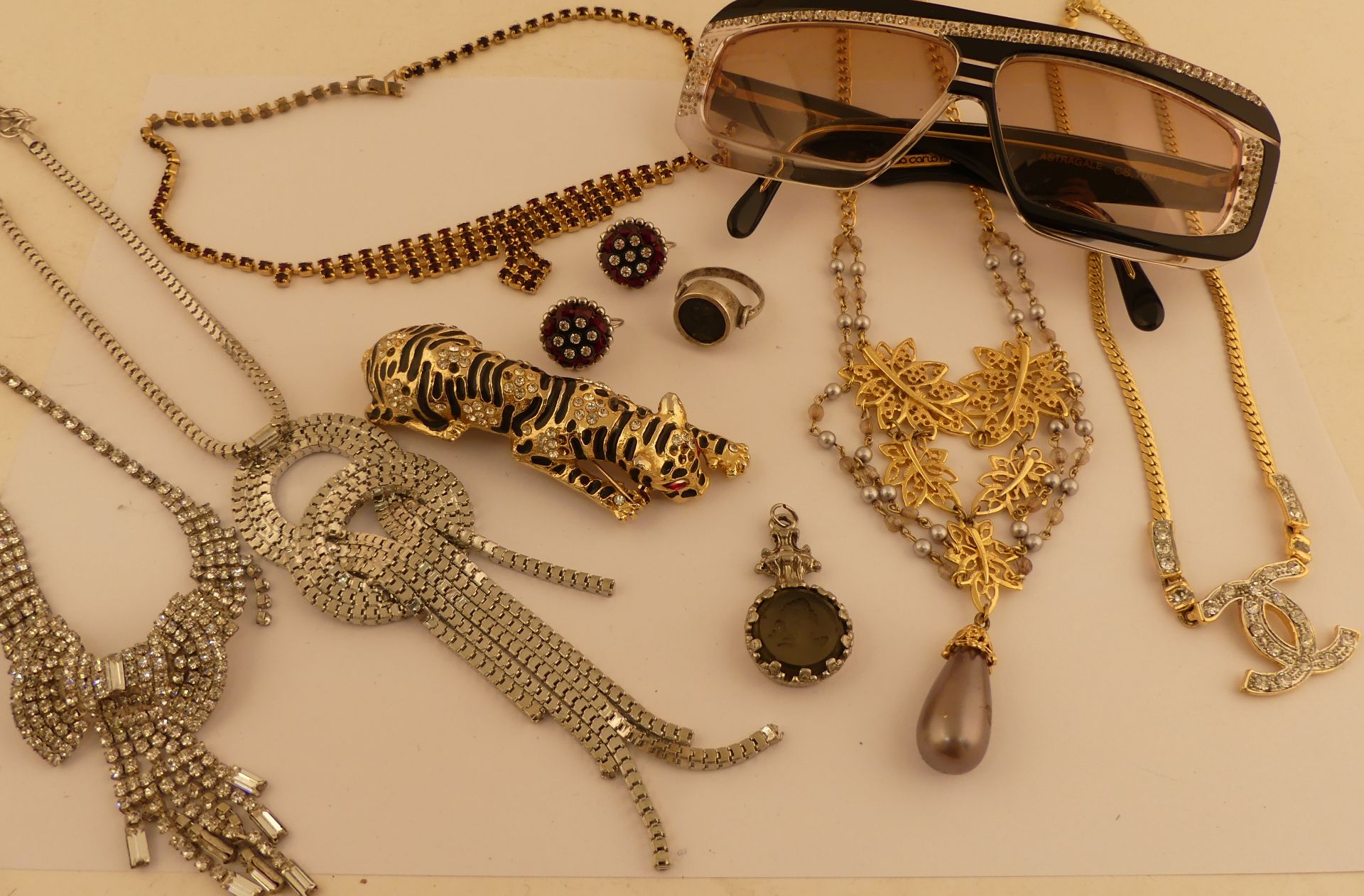 Lot de bijoux fantaisie : 5 colliers et divers. Jointes lunettes de soleil Carlotti. -