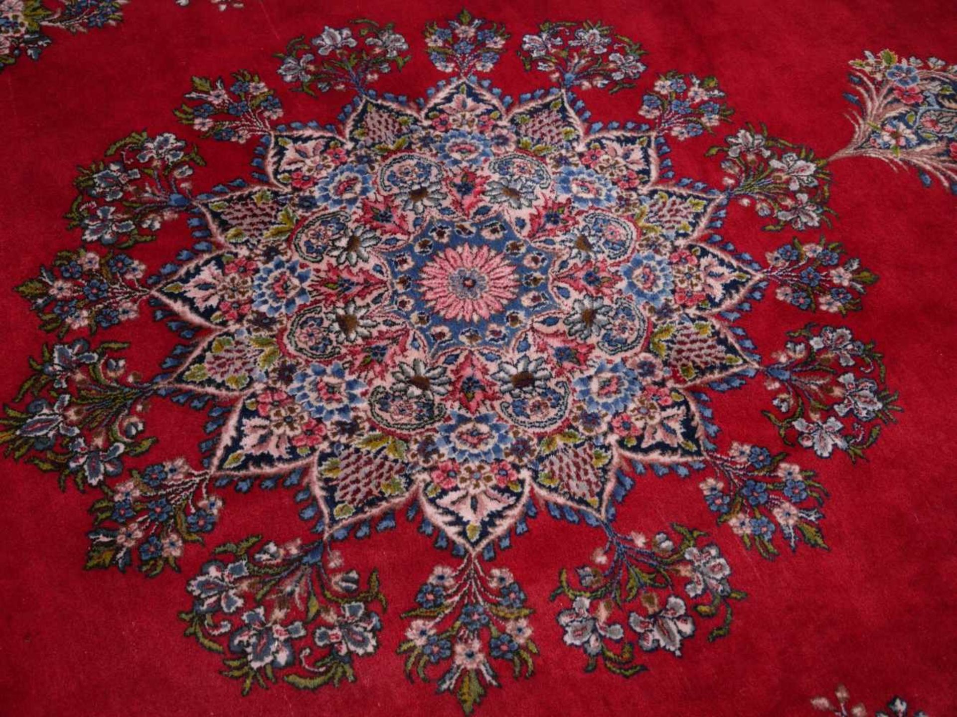 OrientteppichSehr großer Teppich, rotgrundiger Wollflor. Breite ornamentale Bordüre, ovales