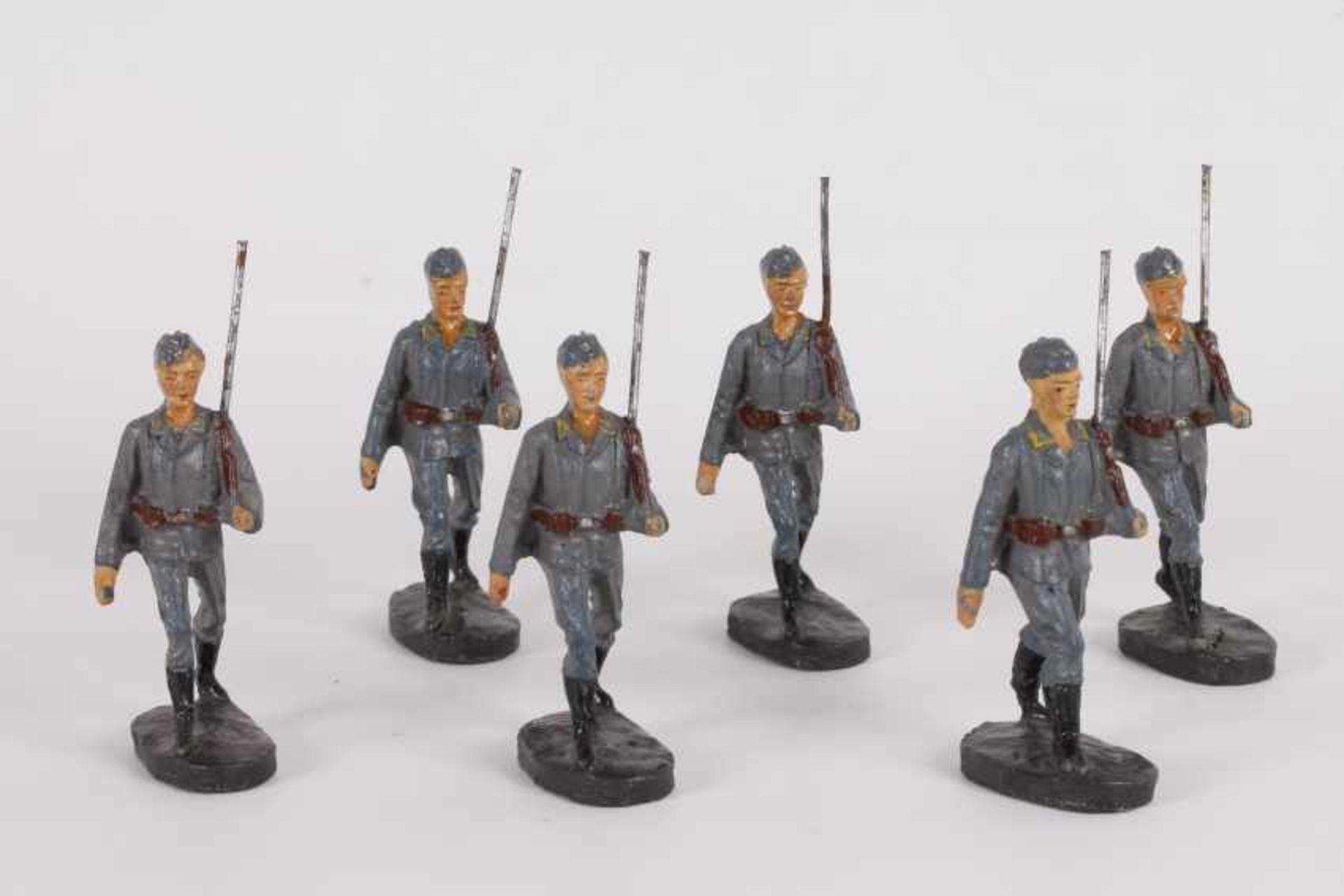 Sechs MassesoldatenSechs Massesoldaten, Elastolin, 7 cm groß, graue Uniformen, marschierend, meist