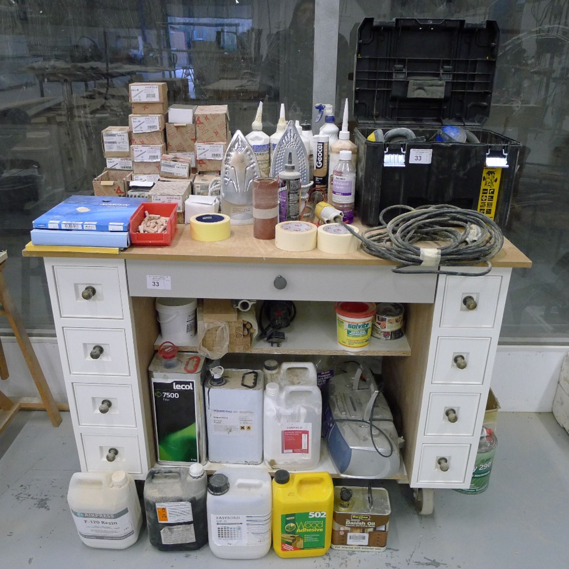 1 wheeled workshop cabinet / bench and a quantity of various items including screws, glues, 2 irons,