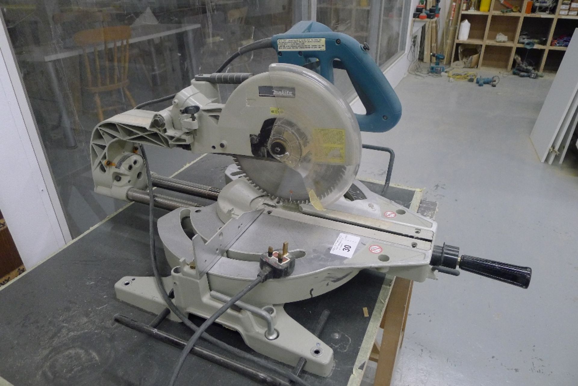 1 sliding mitre saw by Makita type LS1013, 240v with two wooden trestle type stands and a board