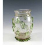 Krautstrunkglas. Farbloses Glas mit aufgeschmolzenen grünen Noppen und gekniffenem Fußrand.