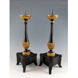 Paar klassizistische Kerzenleuchter. Ebonisiert und vergoldet. Spanien, um 1800. H 60 cm
