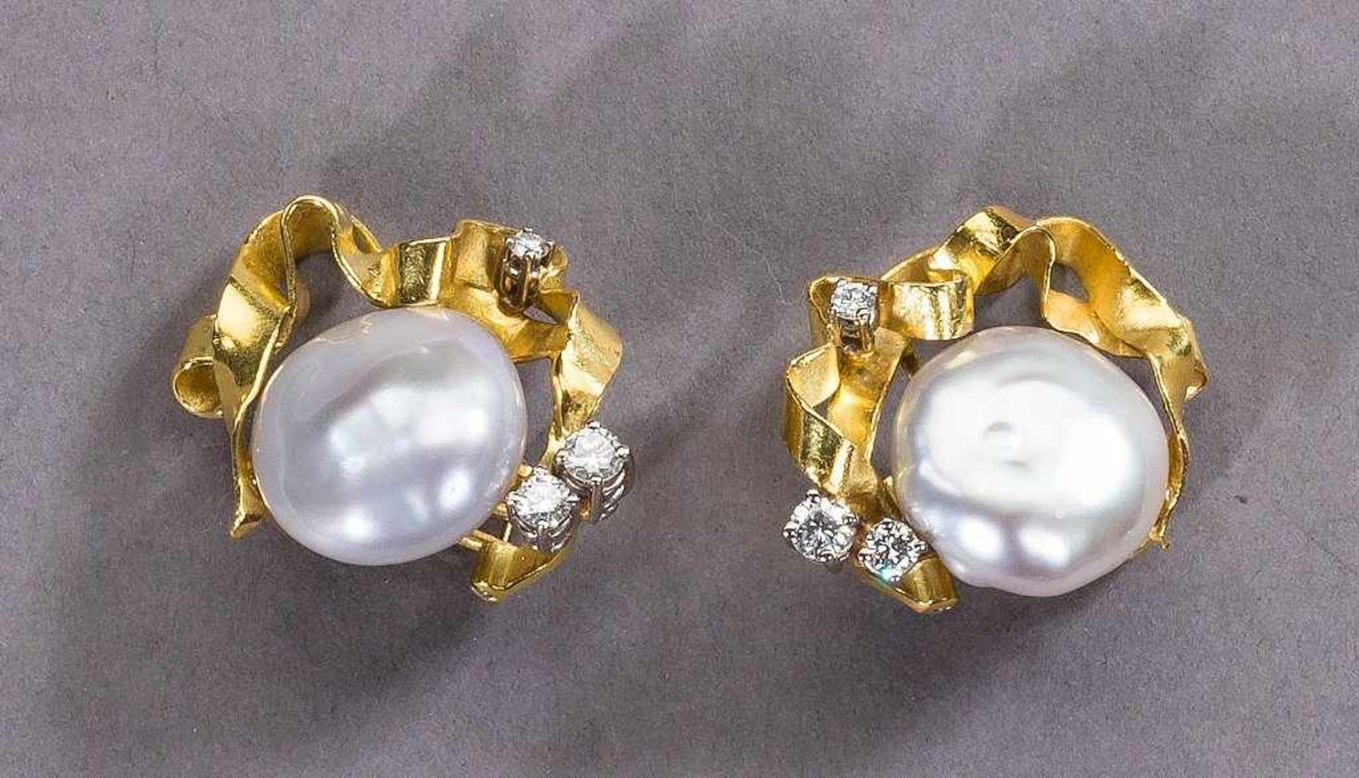 Paar feine Perl-/Brillantohrclips. Flache, leicht barocke Perlen, Ø 14 mm. Brillanten ca. 0,36 ct.