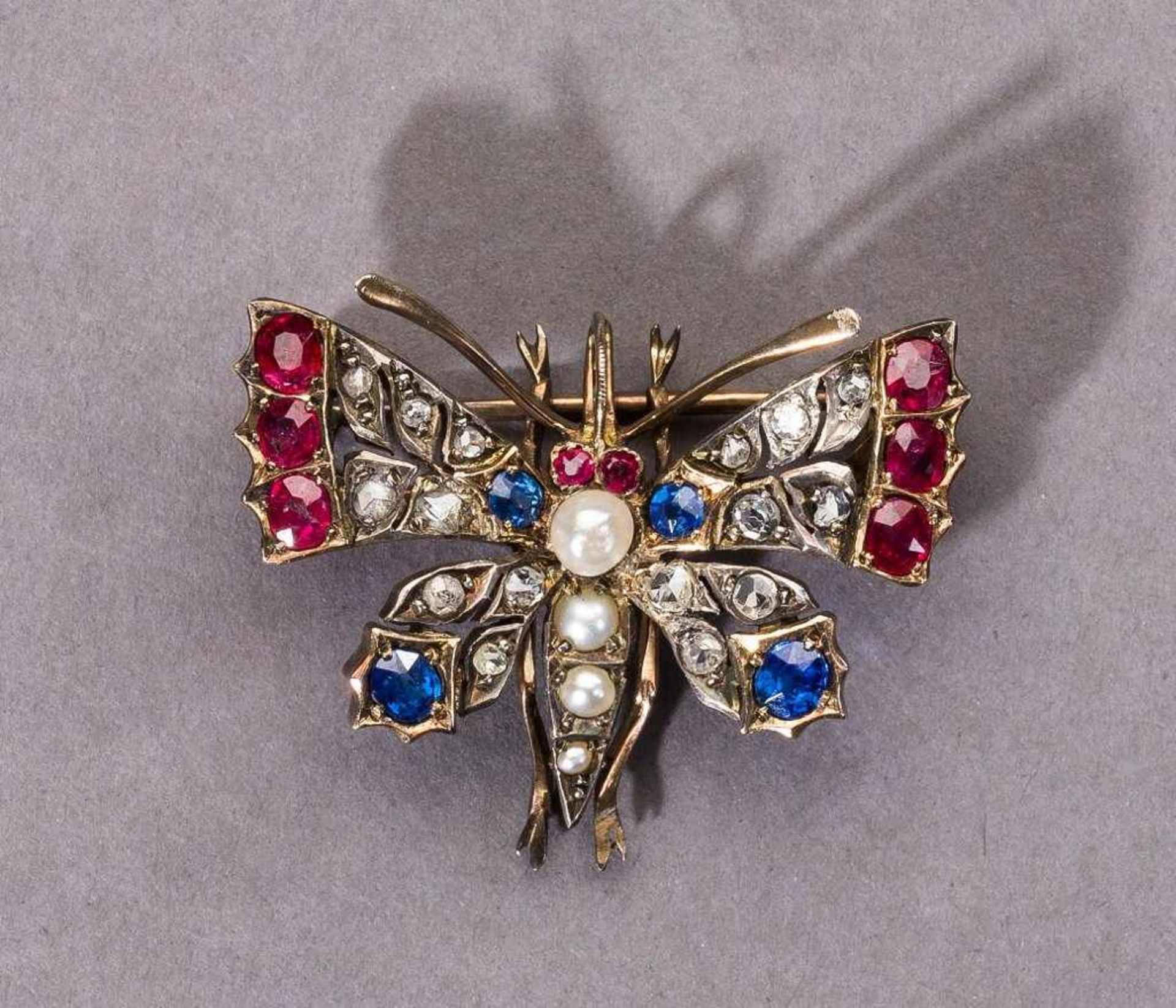 Schmetterlingsbrosche. Diamanten, Rubine, Saphire und kleine Perlen in GG-/Silberfassung.