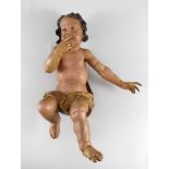 Sitzender Putto in nachdenklicher Pose. Polychrom und golden gefasst. 18./19. Jh. H 52 cm- - -27.