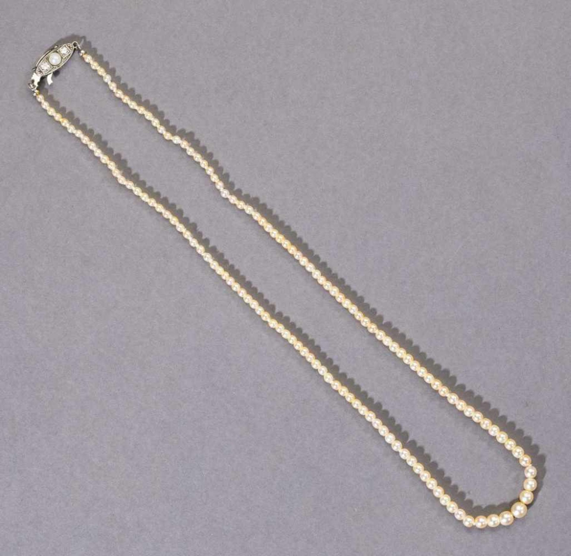 Perlenkette in Verlaufform, vermutlich Orientperlen. Navettförmiges Schloss mit ca. 0,20 ct.