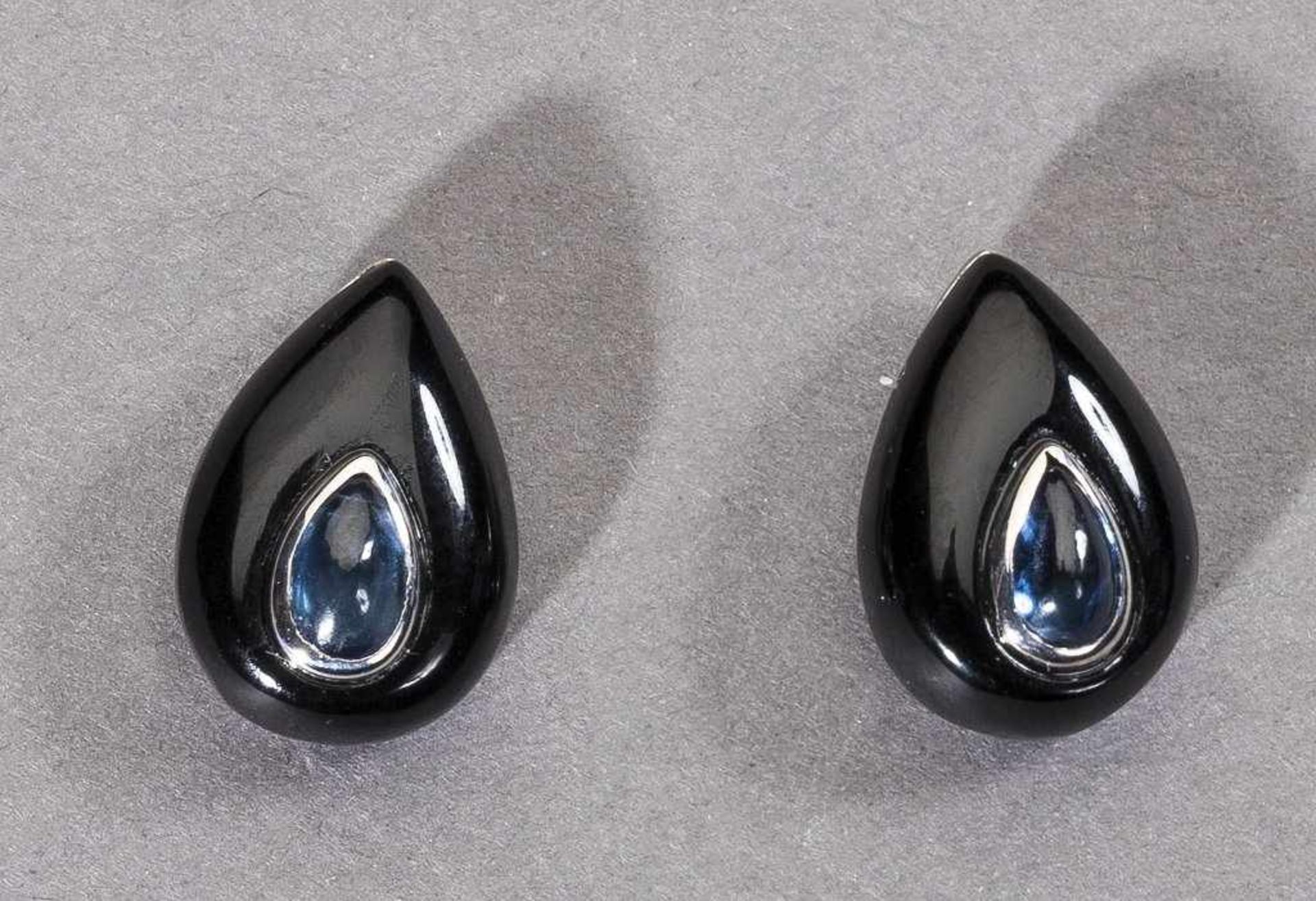 Paar Onyx-/Saphirohrstecker. Tropfenförmiger Onyx, darauf tropfenförmiger Saphir. 18 ct. WG- - -27.