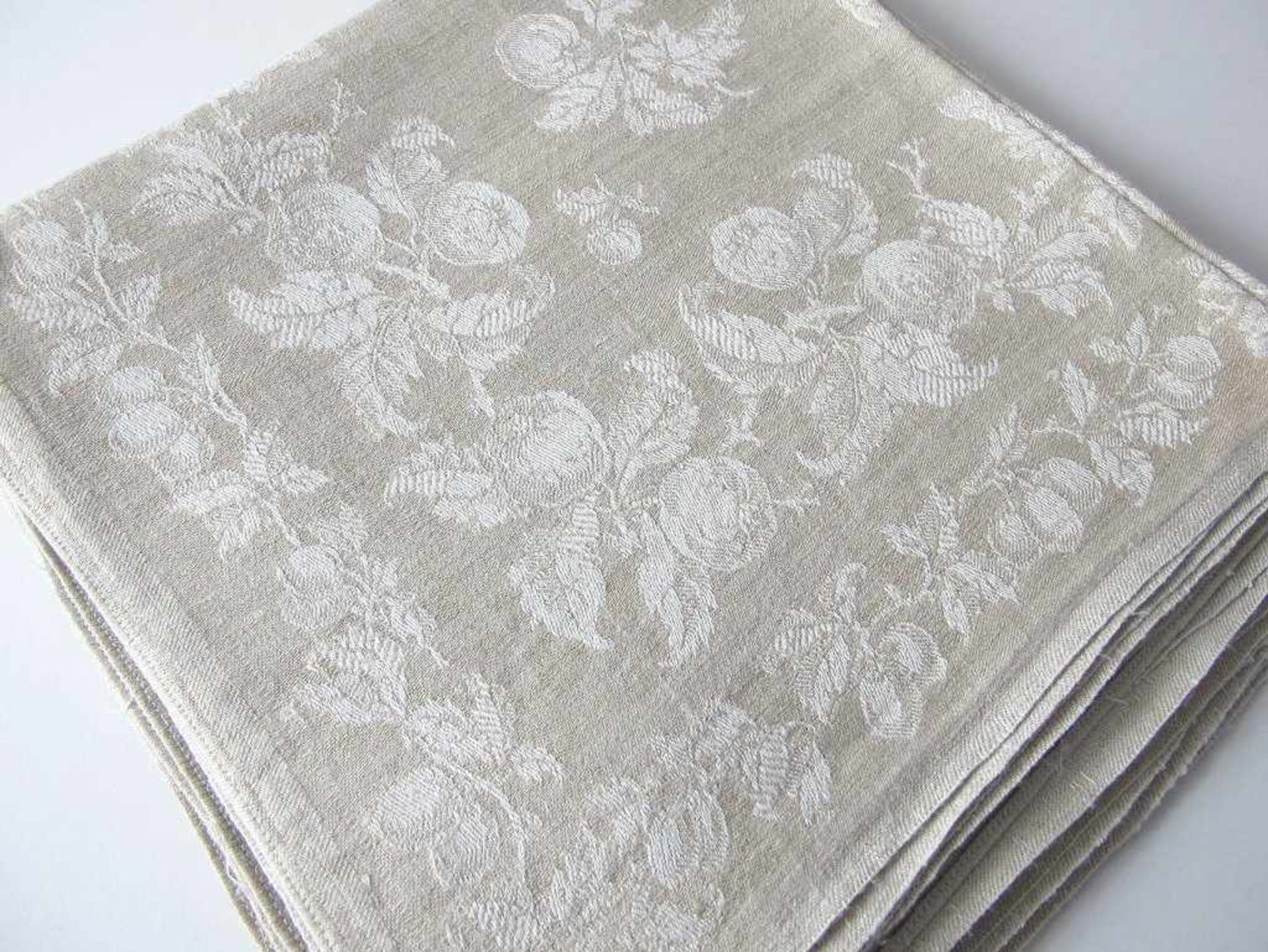 Sechs Teeservietten mit Monogramm "SF". Grauer Leinendamast mit weißen Rosen. Um 1900. 39 x 39 cm- -