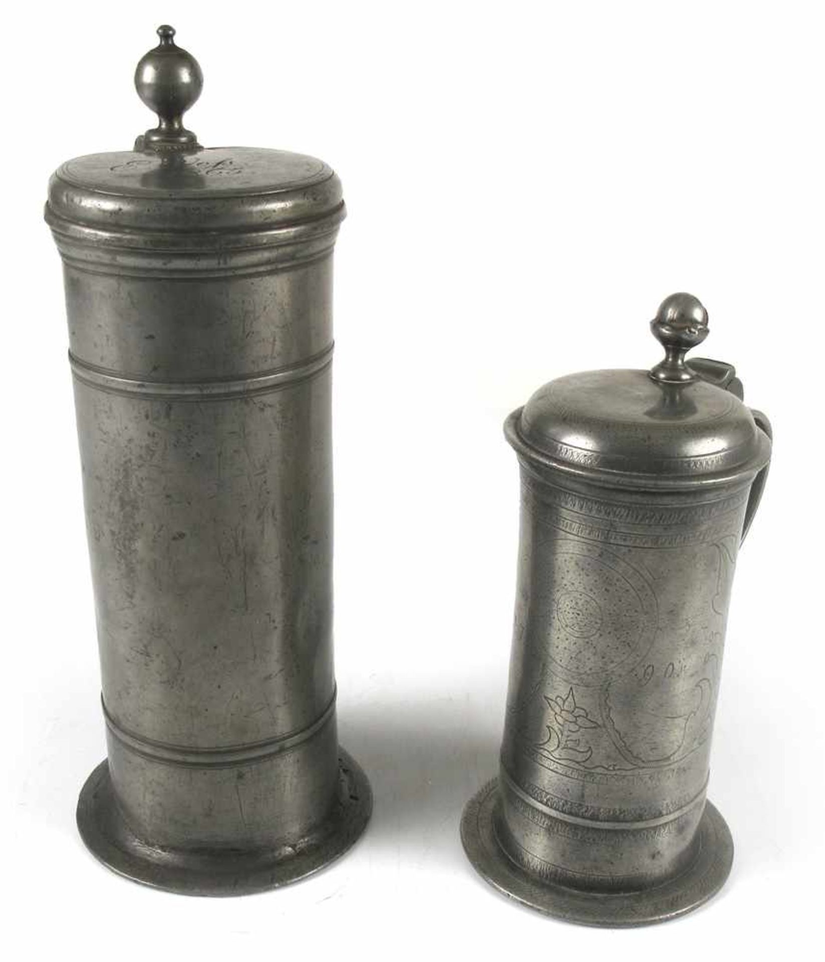 Zwei Zinn-KrügeRendsburg, um 1790/Lübeck, um 1865H. 23,5/32 cmZylindrische Krüge. Beide graviert und