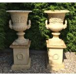 PAIR WHITE CAST IRON URNS ON PLINTH