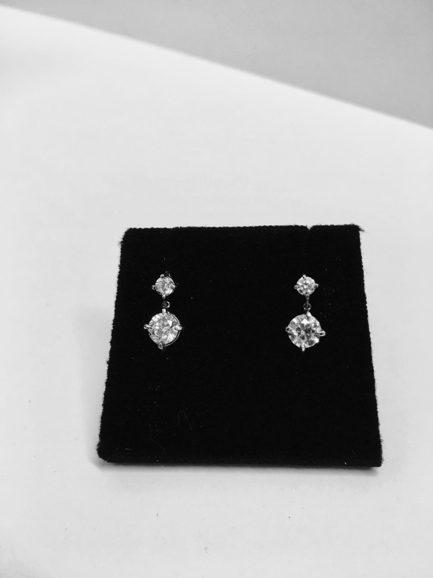 18ct white gold drop style earrings. Each has 2 brilliant cut diamonds