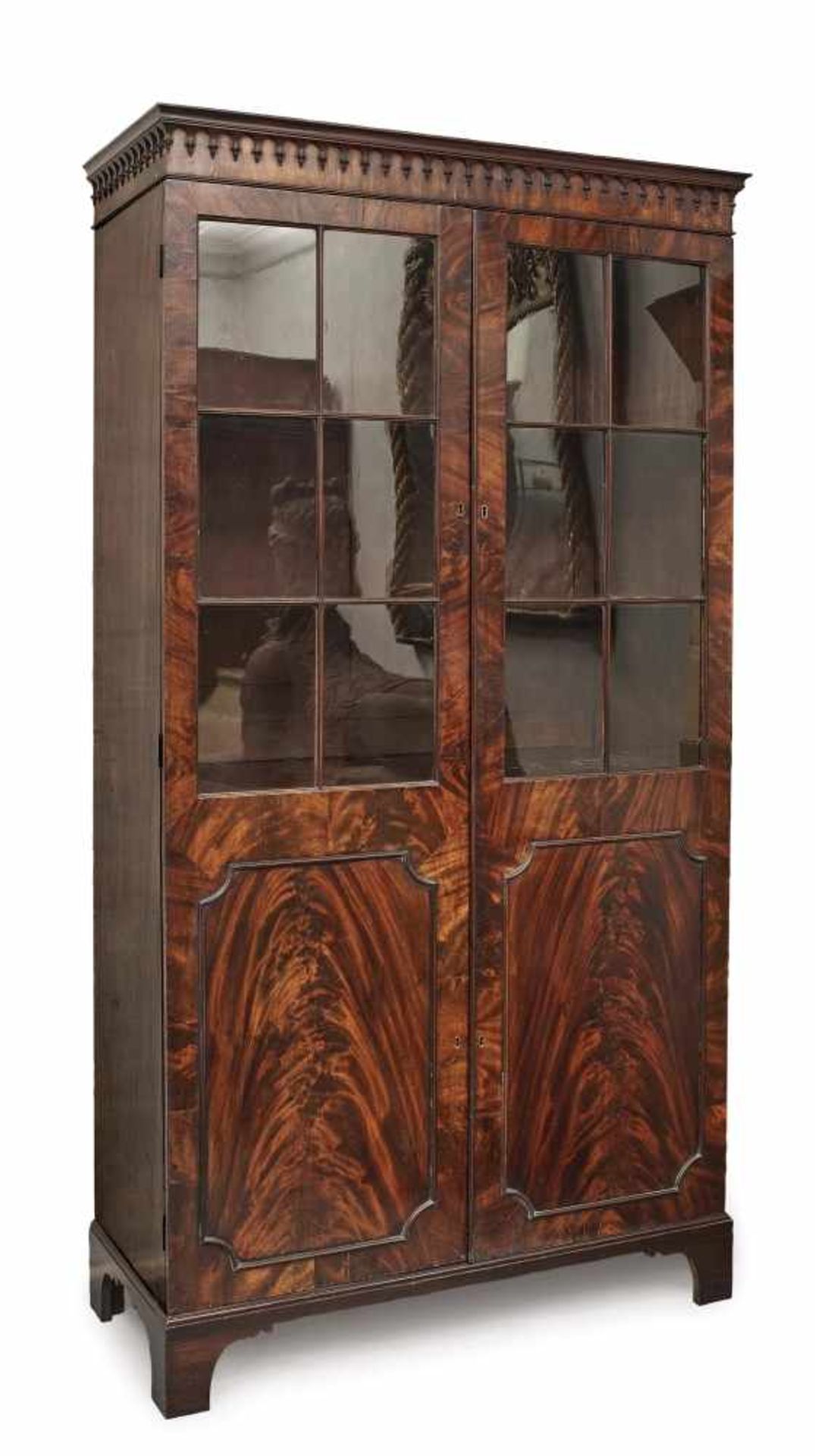 A showcaseEngland, 18th/19th century Mahogany. Doors glazed on the upper half. Relief decoration.