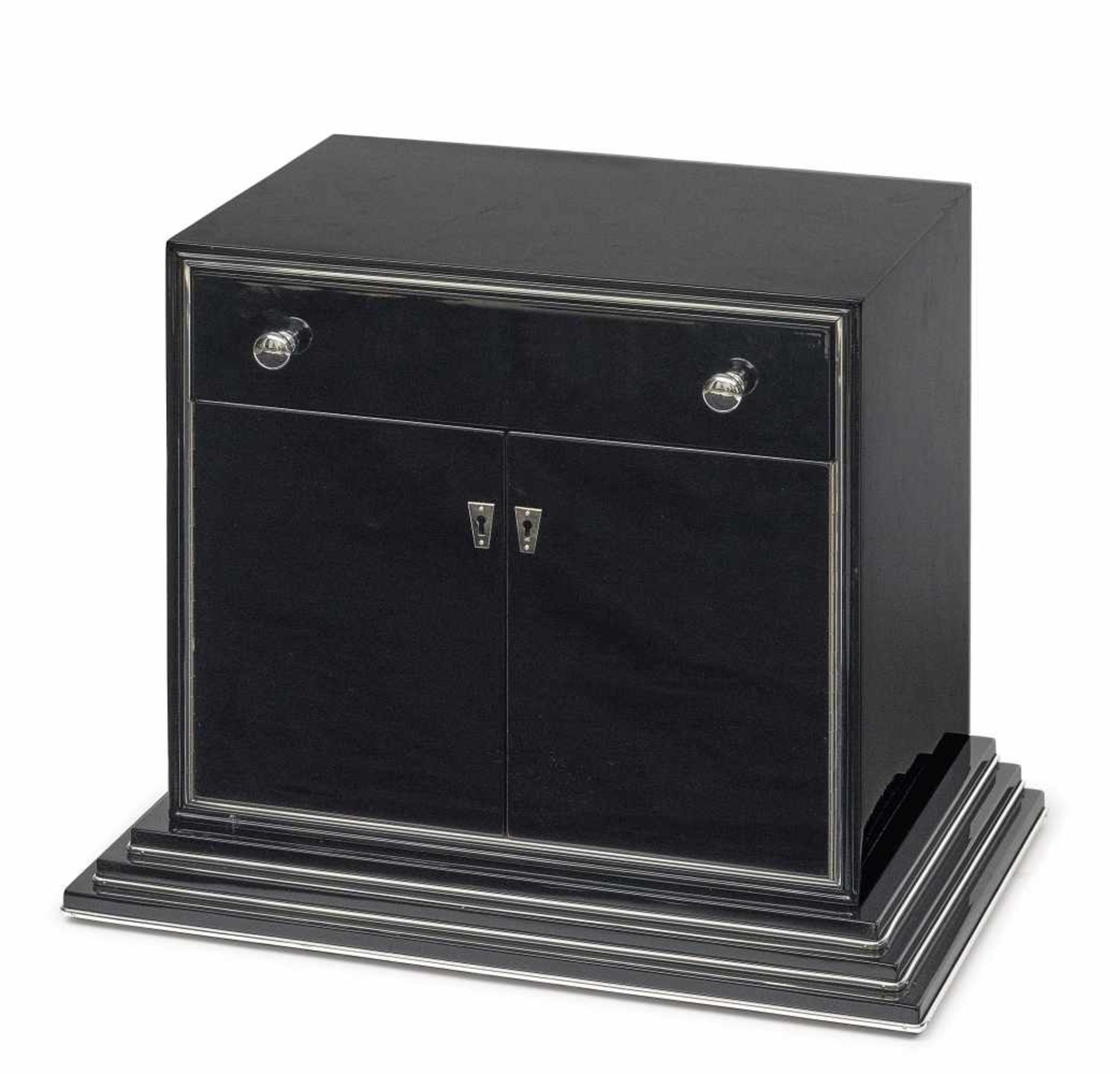 A small Art Deco cabinetFrance, circa 1925 Wood, painted in black. Chrome-plated metal bands and