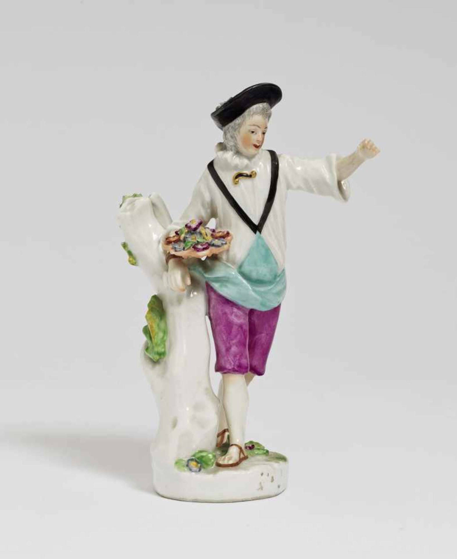 A figure of a gardenerVienna, 18th century Porcelain. Polychrome and gold decoration. Blue shield