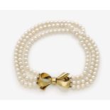 A Three-Strand Pearl Necklace with Bow-Shaped ClaspAustria, 1950s 18K yellow gold (750/-),