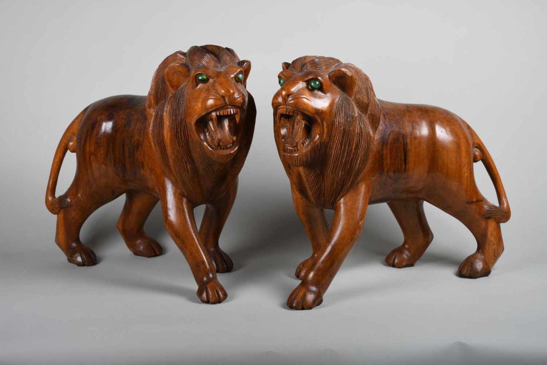 Paar geschnitzte Löwenplastikennaturnahe Darstellung zweier gegensätzlicher schreitender Löwen mit