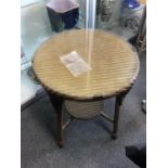 A Lloyd Loom circular table, glass clip-on top, circular undertray to X form stretcher, gold finish,