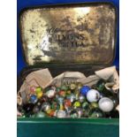 A small quantity of glass marbles, in a vintage Lyons Green Label Tea Box (qty)