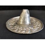 A Mexican sombrero hat pin tray, decorated with repousse work with further chasing of a garland of