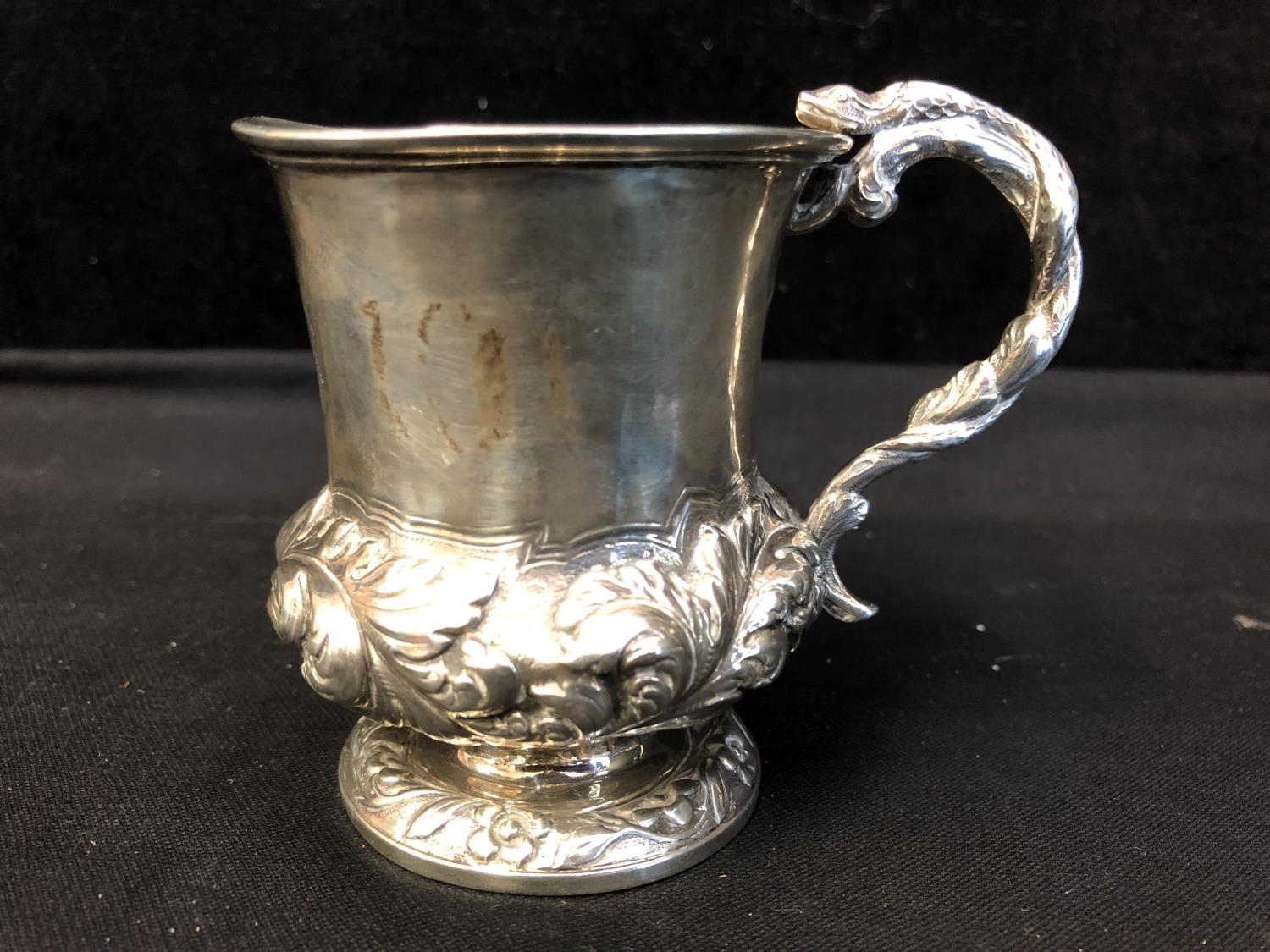 A Georgian silver small mug, the bell form body applied with serpent 's' scroll handle and on