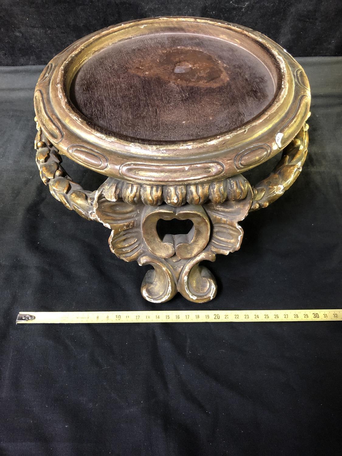 A large gilded gesso vase stand, circular with laurel leaf stretcher and on 'c' scroll feet,