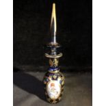 A Beykoz glass bottle and spire stopper, the cobalt blue ground decorated with reserves containing
