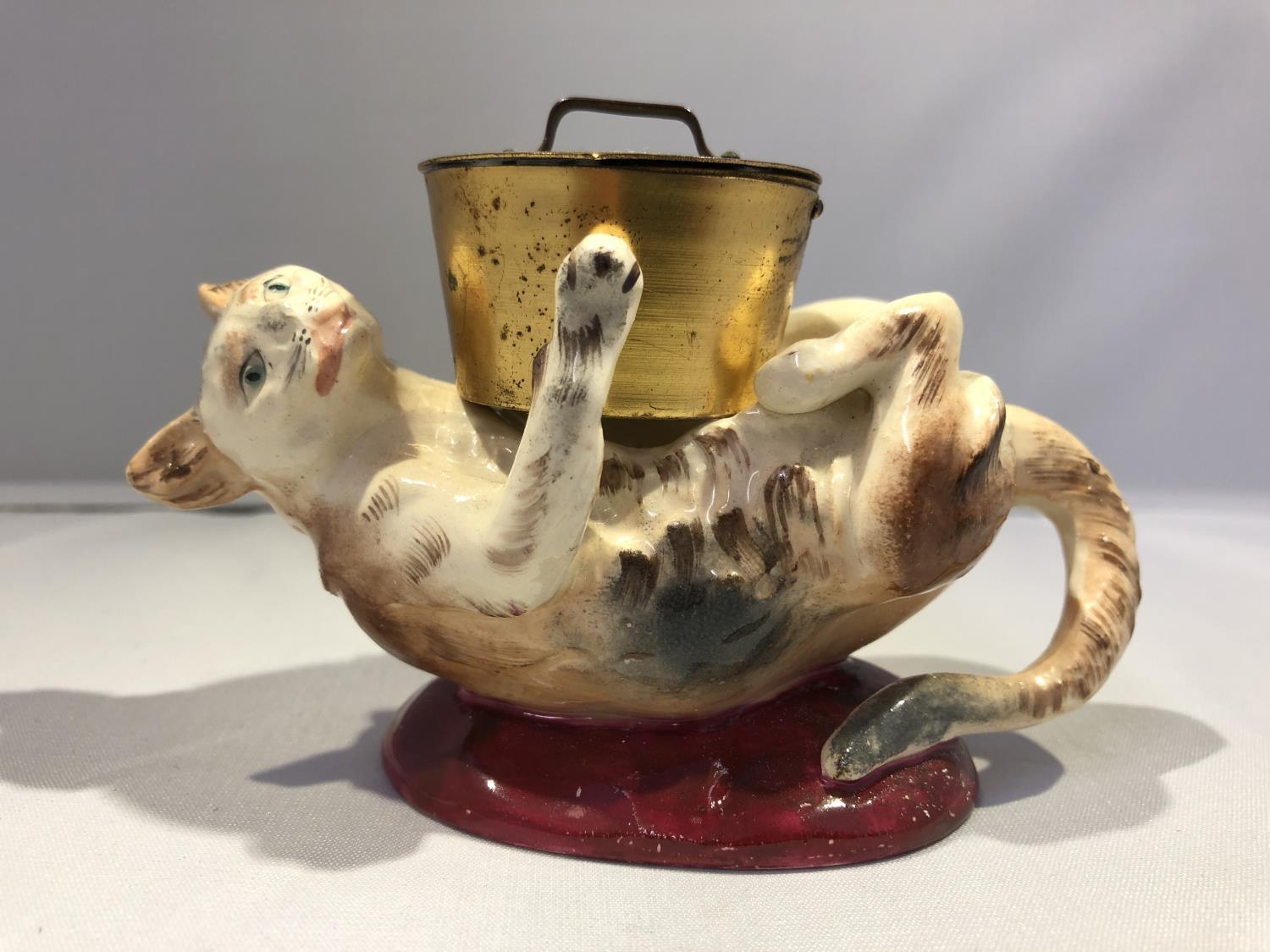 A Georges Dreyfus pottery novelty ink well, formed as a kitten on its back playing with a cooking