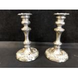 A Pair of George II silver candlesticks, decorated throughout with florets and scalloped 'c'