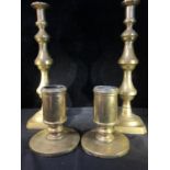 A pair of brass altar candlesticks, cylindrical on wide circular bases; and a pair of tall brass