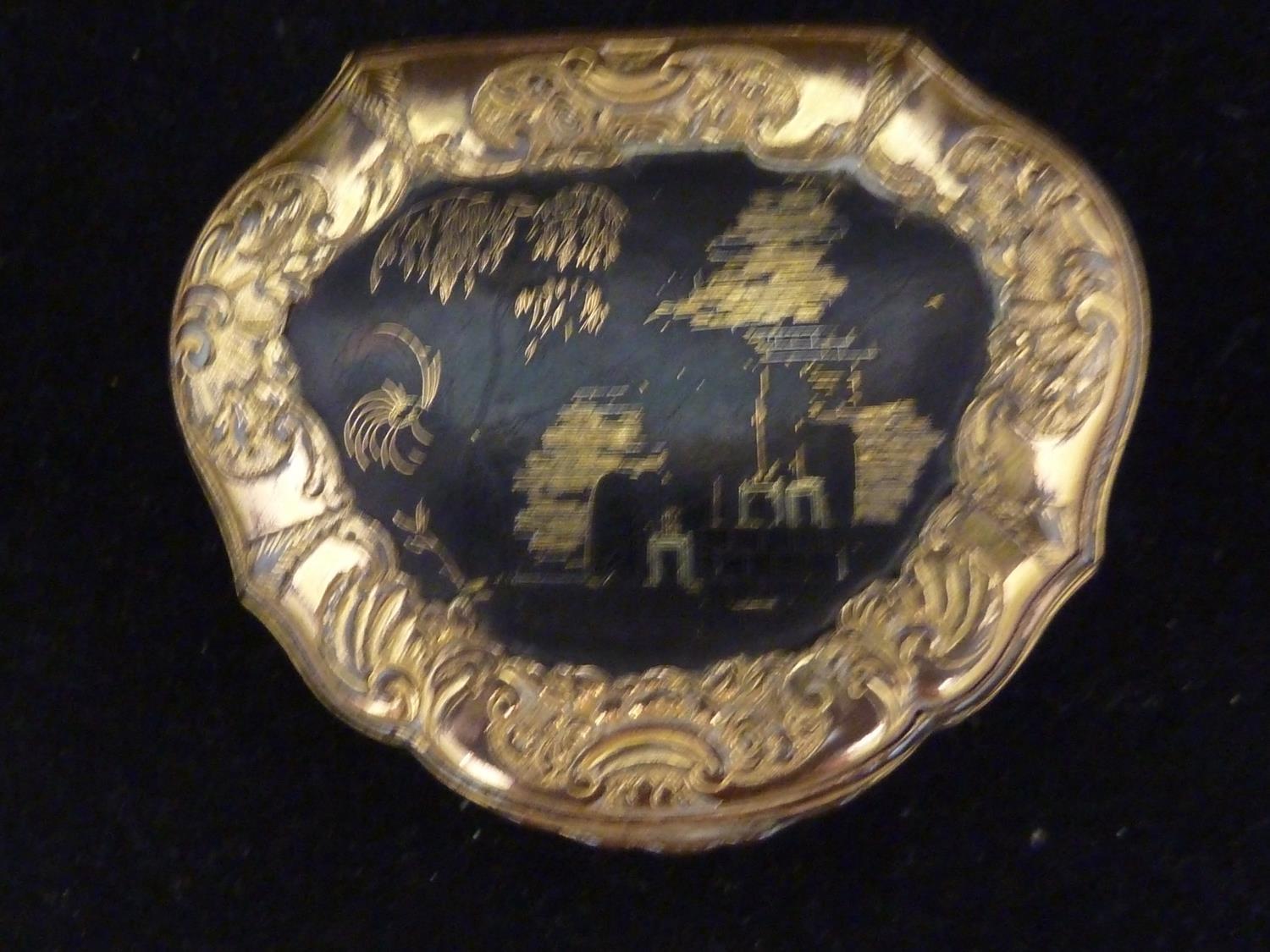 A gilt metal snuff box, in Louis XV style, of bombe form decorated with foliate scrolls and on three