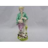 A Meissen figure of a travelling musician and dog, he standing resting on a tree stump playing a