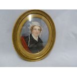 A Regency portrait miniature, of a woman with ringlets and lace cap, in an oval gilded metal frame
