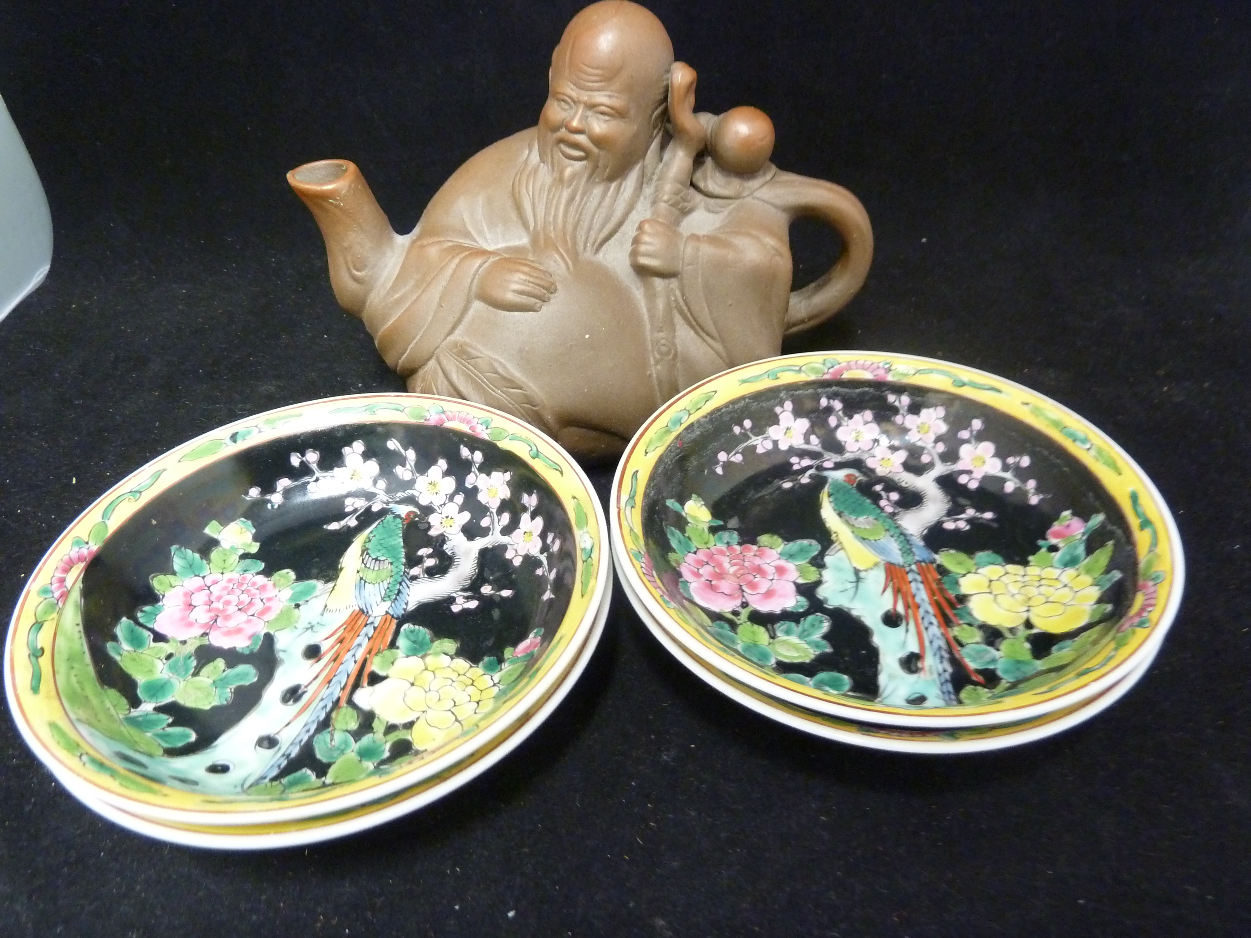 A Chinese Yixing pottery teapot and cover, in the form of a sage; and four Straights type