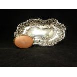 A Silver Rococo form pin tray, of irregular form composed of foliate 'c' scrolls and pierced