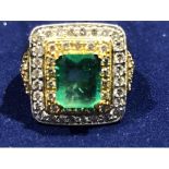 A Columbian emerald and diamond ring, the central emerald cut emerald of approx 2.07ct, within afour