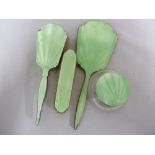 A four piece enamelled silver dressing table set, of pale green enamel comprising hand mirror,