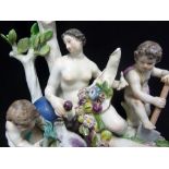 A Meissen porcelain figure of Mother Earth and putti, she reclining against tree stumps supporting a