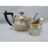 A batchelors size silver teapot, of half gadrooned London shape' and a milk jug, conforming,