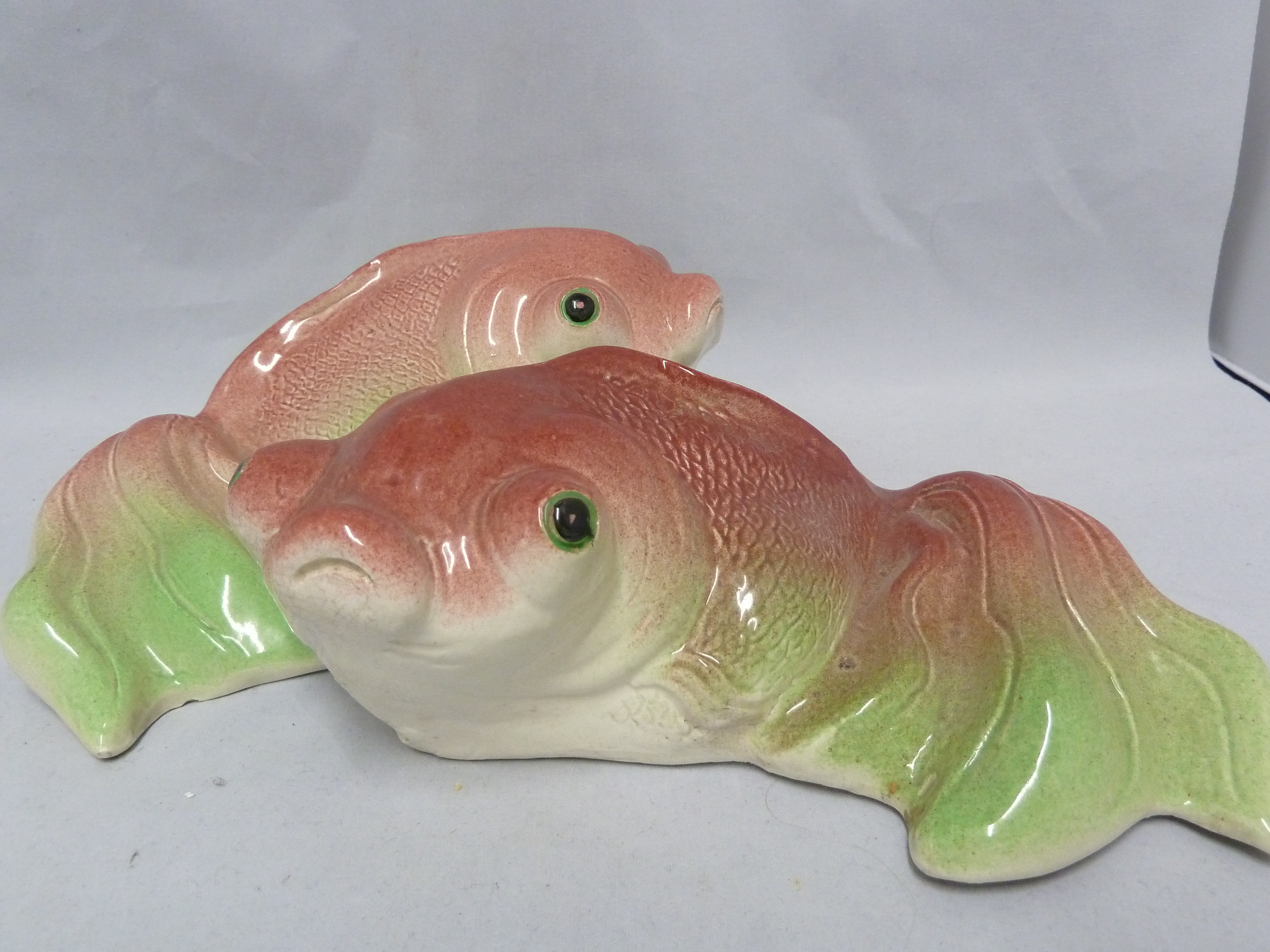 Two Chinese pottery wall pockets, formed as Koi carp, coloured in red and green, character marks